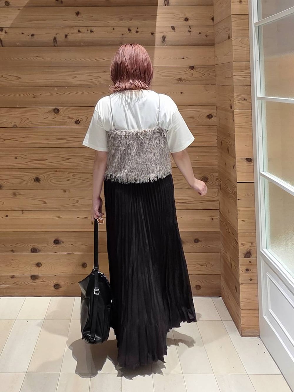 グレー系のスカート、ブラック系のローファー、ホワイト系のTシャツ/カットソーを着用したレディースの秋コーディネートの3枚目の写真
