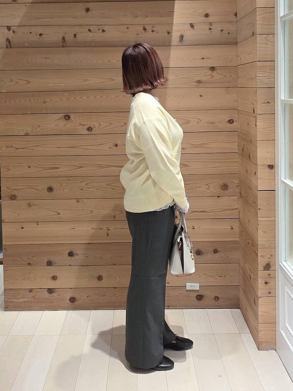 ブラック系のローファー、ホワイト系のショルダーバッグ、ホワイト系のTシャツ/カットソーを着用したレディースの冬コーディネートの2枚目の写真