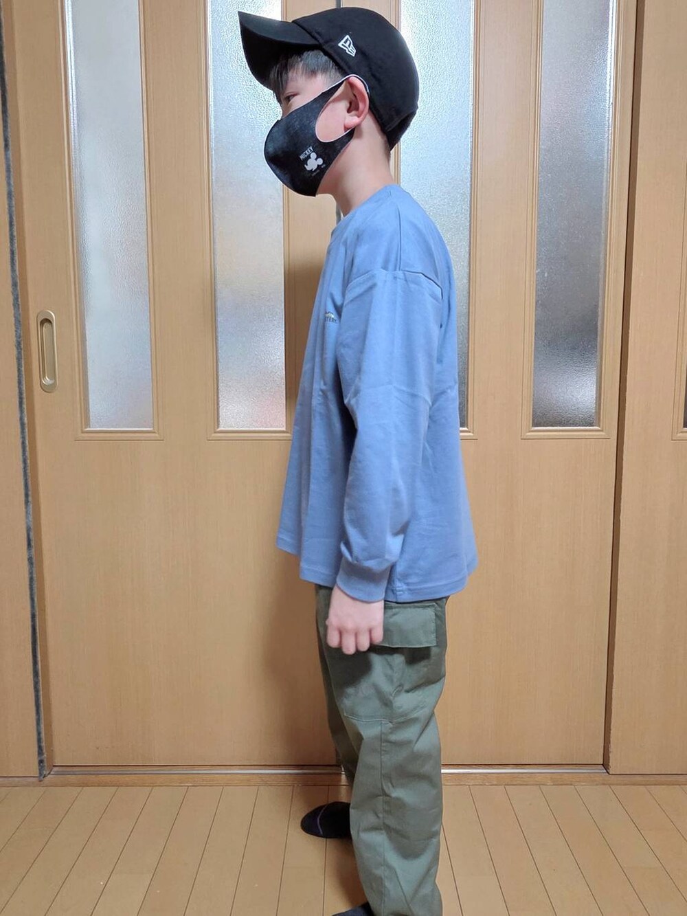 グリーン系のカーゴパンツ、ブルー系のTシャツ/カットソー、ブラック系のキャップを着用したキッズの秋コーディネートの2枚目の写真