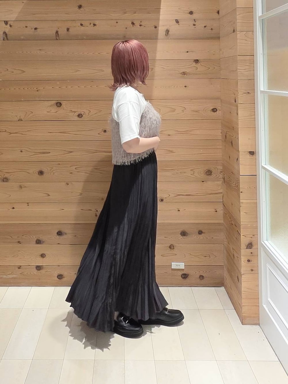 グレー系のスカート、ブラック系のローファー、ホワイト系のTシャツ/カットソーを着用したレディースの秋コーディネートの2枚目の写真