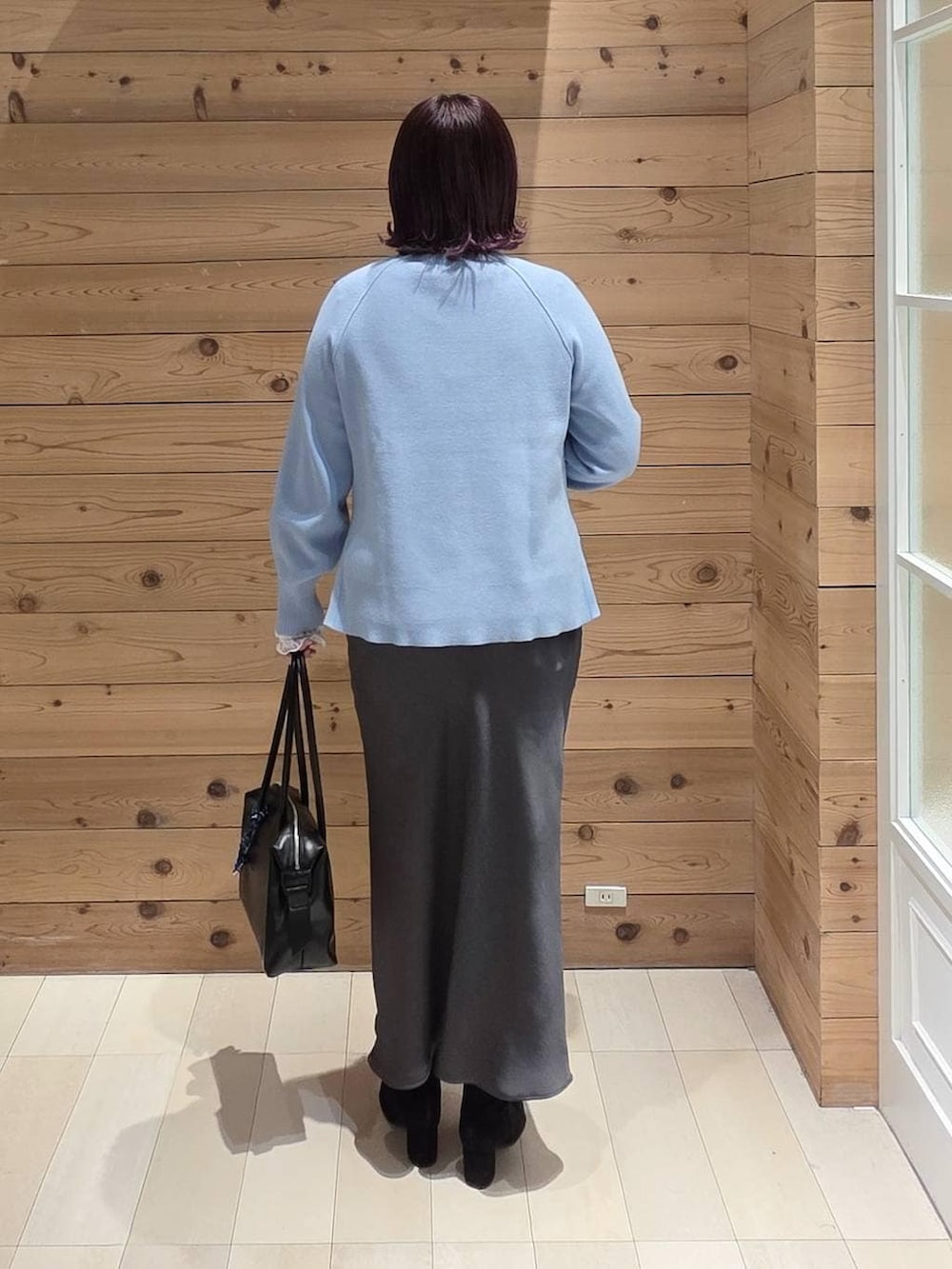 ブラック系のボストンバッグ、グレー系のチェスターコート、ホワイト系のTシャツ/カットソーを着用したレディースの冬コーディネートの3枚目の写真