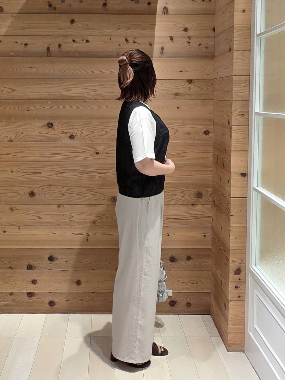 ベージュ系のその他パンツ、ホワイト系のTシャツ/カットソー、ブラウン系のサンダルを着用したレディースの夏コーディネートの2枚目の写真