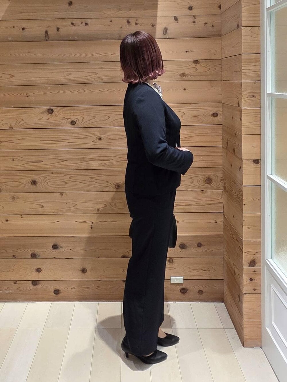 ブラック系のショルダーバッグ、ブラック系のパンプス、ブルー系のセットアップを着用したレディースの冬コーディネートの2枚目の写真