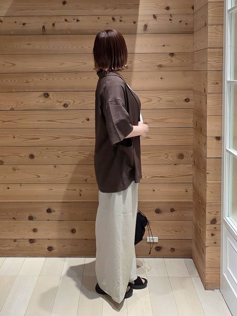 ブラウン系のテーラードジャケット、ホワイト系のTシャツ/カットソー、ブラック系のサンダルを着用したレディースの春コーディネートの2枚目の写真