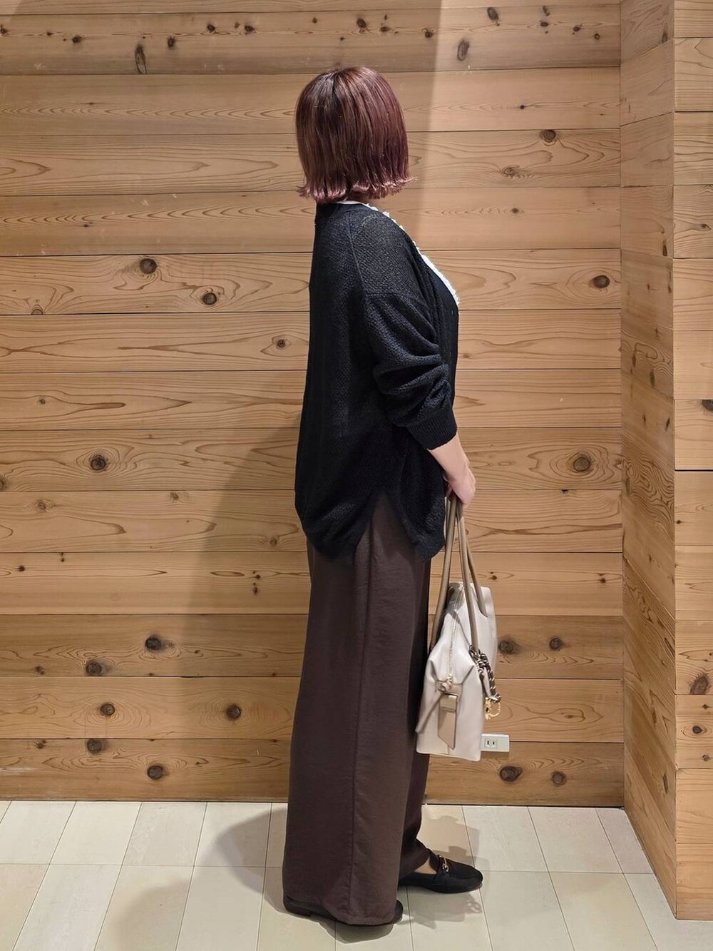 ブラック系のローファー、ブラウン系のその他パンツ、ホワイト系のボストンバッグを着用したレディースの秋コーディネートの2枚目の写真