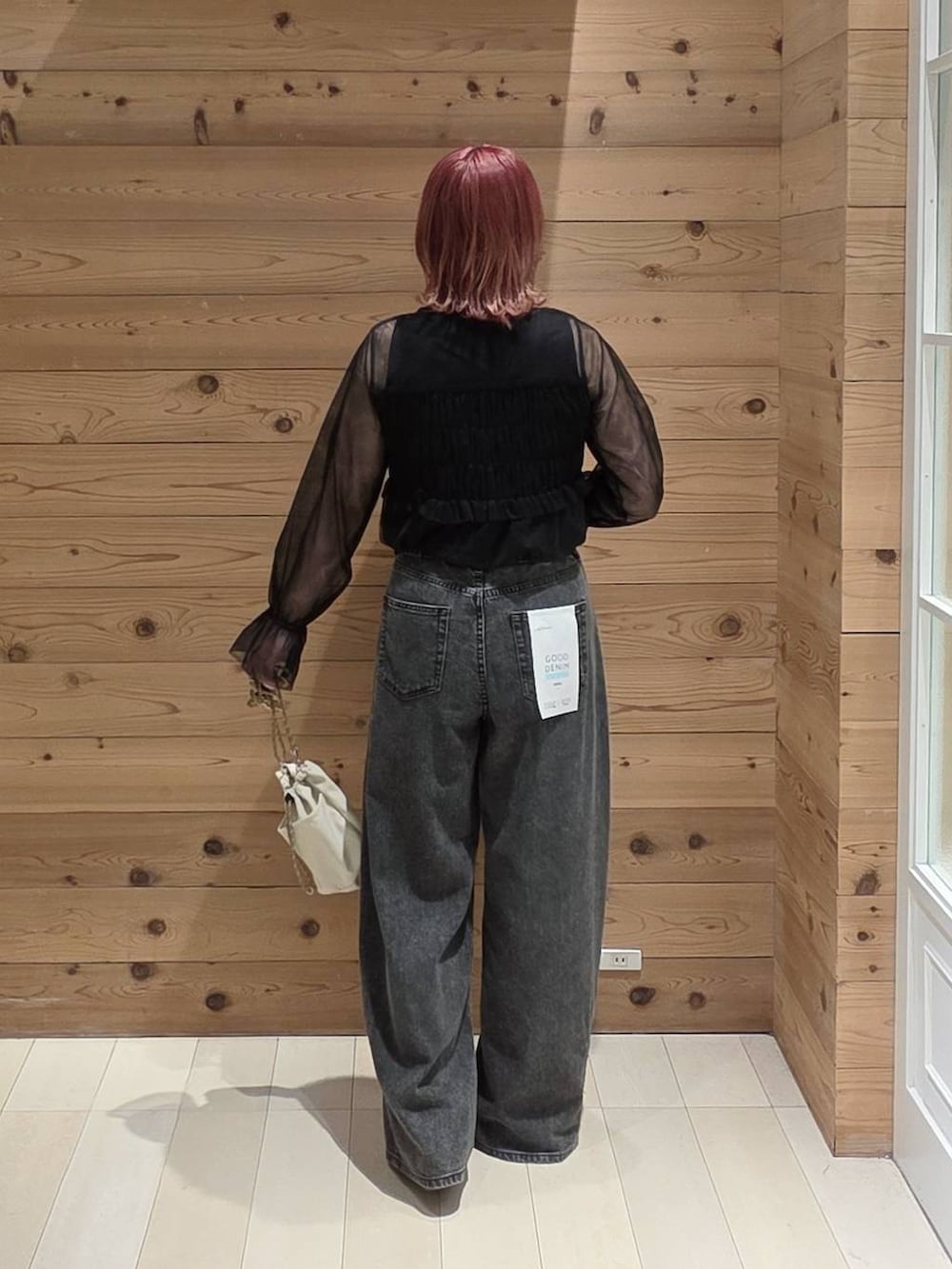ブラック系のデニムパンツ、ブラック系のタンクトップ、ベージュ系のボディバッグ/ウエストポーチを着用したレディースの夏コーディネートの3枚目の写真