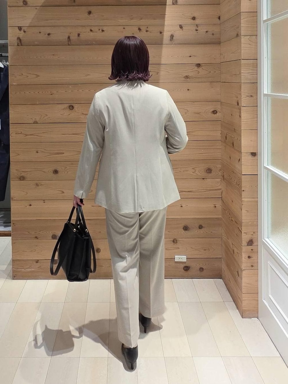 ブラック系のパンプス、ベージュ系のスラックス、ホワイト系のシャツ/ブラウスを着用したレディースの冬コーディネートの3枚目の写真