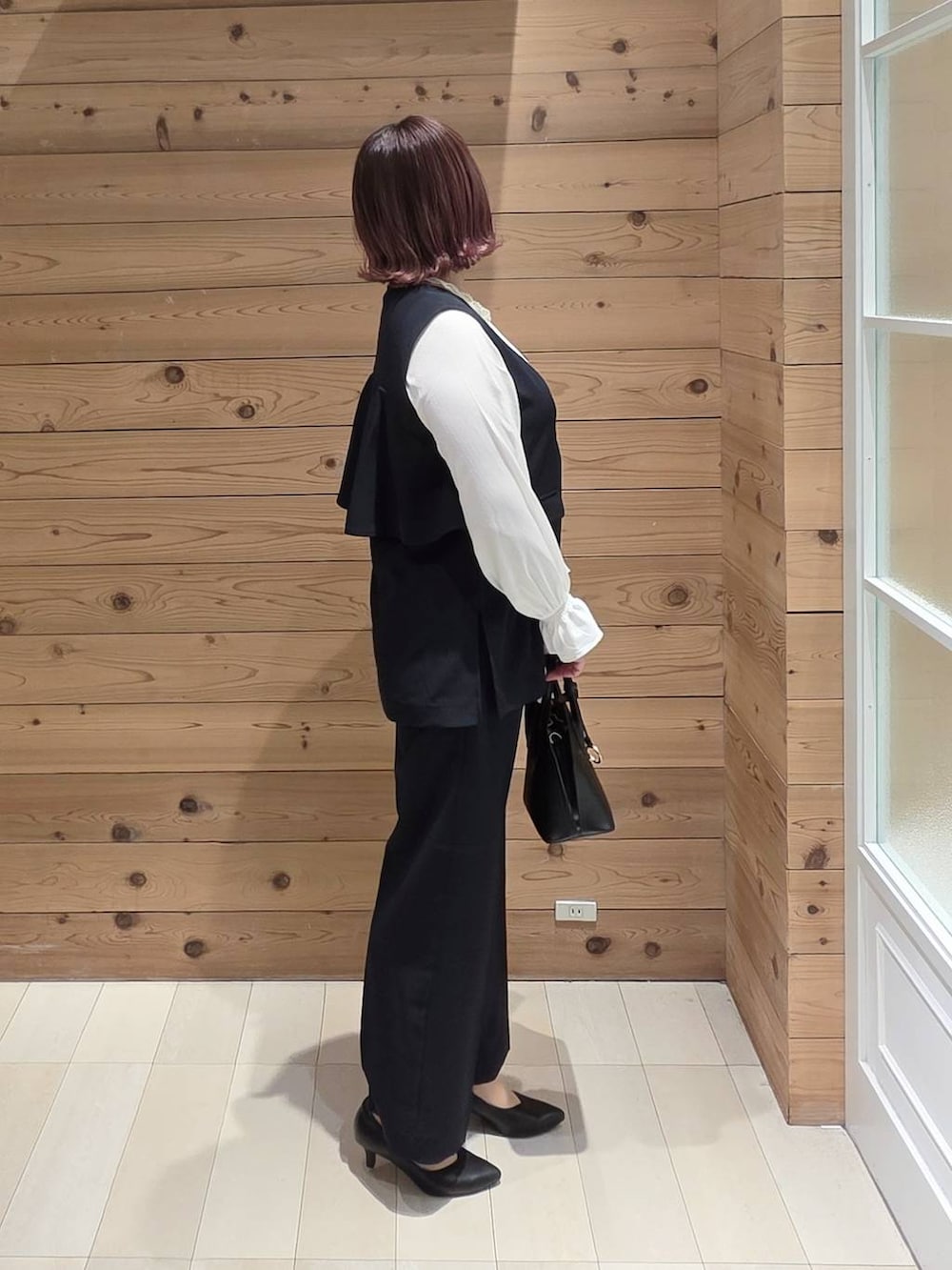 ブラック系のショルダーバッグ、ブラック系のパンプス、ブルー系のセットアップを着用したレディースの冬コーディネートの2枚目の写真