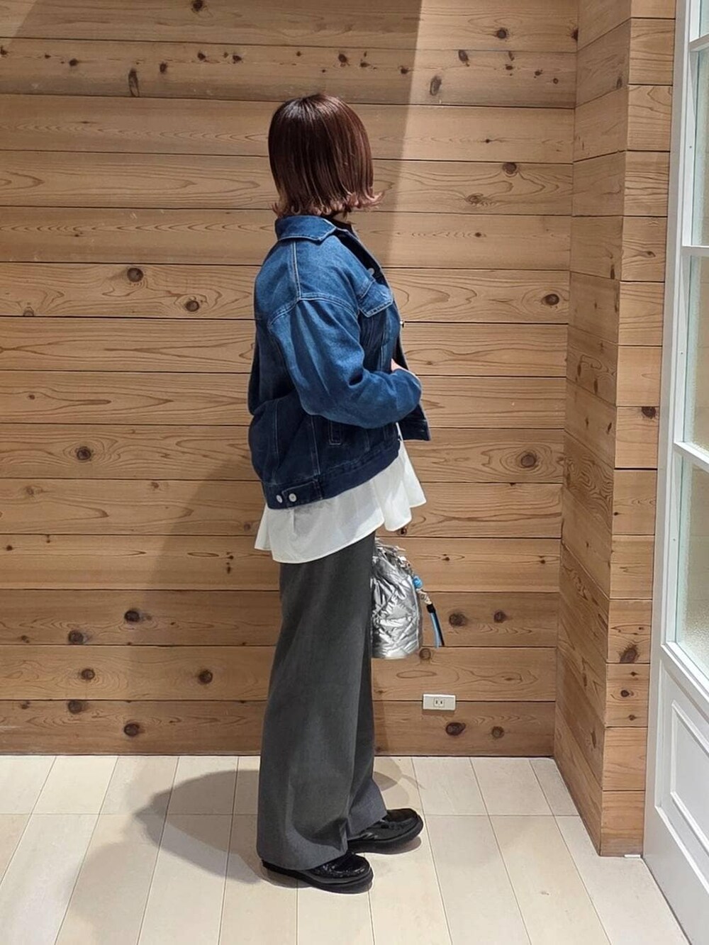 ブラック系のローファー、シルバー系のハンドバッグ、ホワイト系のTシャツ/カットソーを着用したレディースの冬コーディネートの2枚目の写真