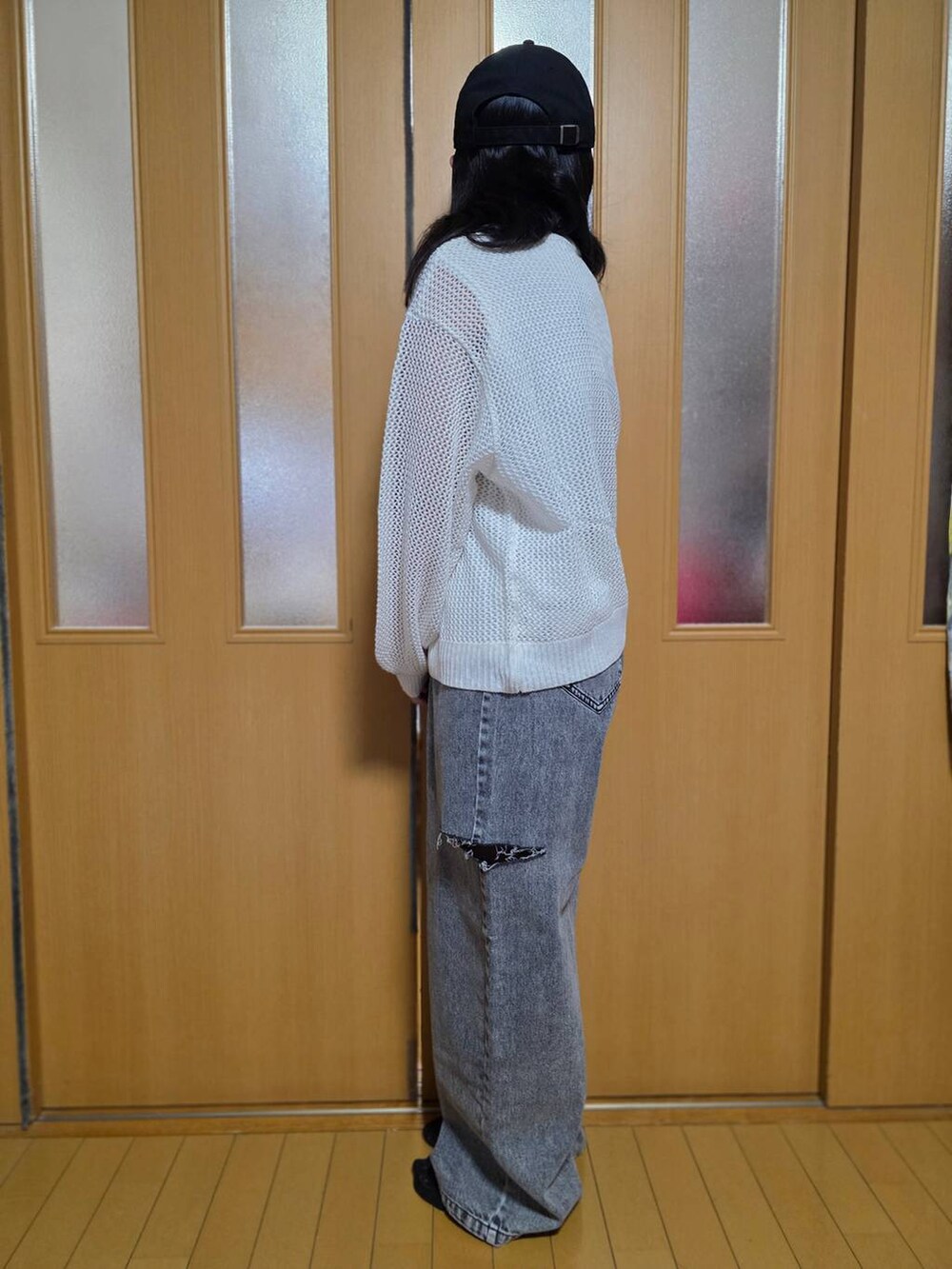 ブラック系のデニムパンツ、ホワイト系のニット/セーター、ブラック系のキャップを着用したキッズの秋コーディネートの2枚目の写真