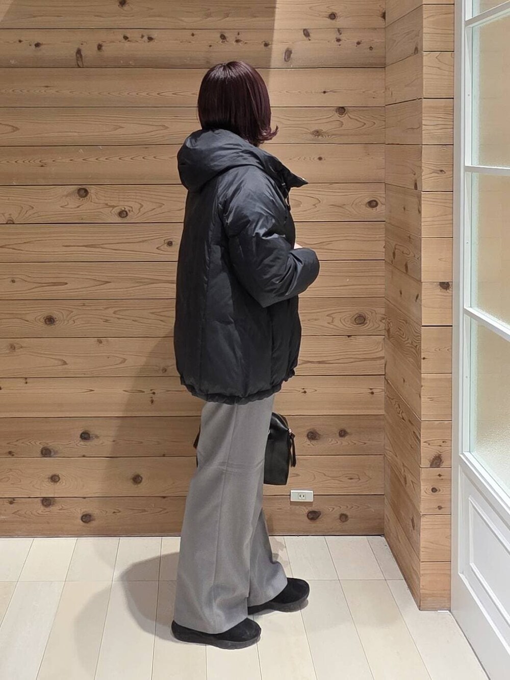 ブラック系のダウンジャケット/コート、ブラック系のボストンバッグ、ブラック系のブーツを着用したレディースの冬コーディネートの2枚目の写真