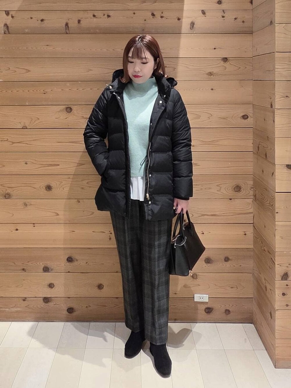 ブラック系のショルダーバッグ、ブラック系のダウンジャケット/コート、ブラック系のその他パンツを着用したレディースの冬コーディネートの4枚目の写真