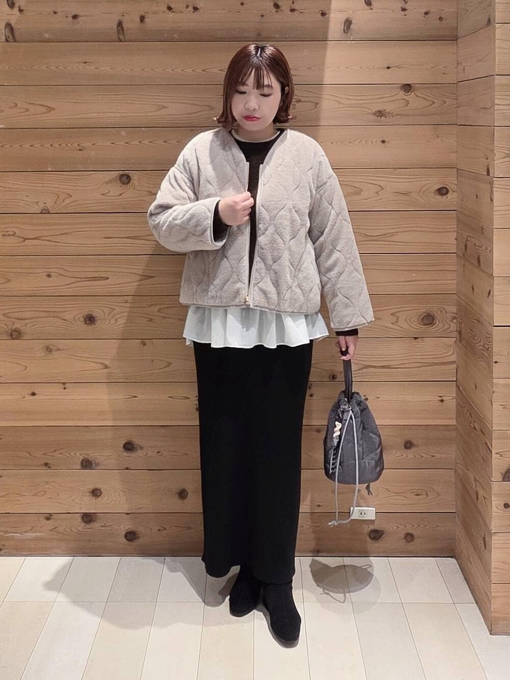 ベージュ系のブルゾン、グレー系のハンドバッグ、ブラウン系のニット/セーターを着用したレディースの冬コーディネートの4枚目の写真