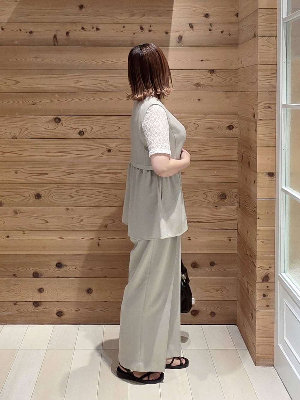 ベージュ系のベスト、ベージュ系のその他パンツ、ブラック系のタンクトップを着用したレディースの夏コーディネートの2枚目の写真