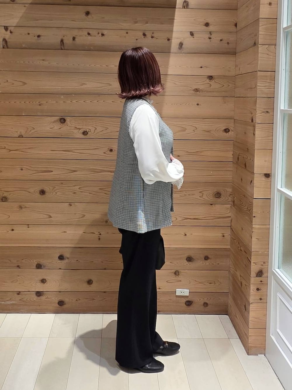 ブラック系のローファー、ブラック系のショルダーバッグ、ホワイト系のシャツ/ブラウスを着用したレディースの春コーディネートの2枚目の写真