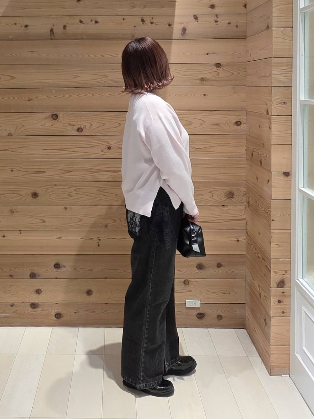 ブラック系のローファー、ブラック系のデニムパンツ、ピンク系のニット/セーターを着用したレディースの春コーディネートの2枚目の写真