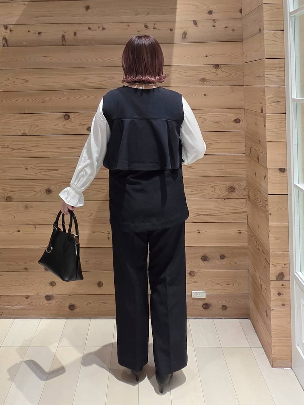 ブラック系のショルダーバッグ、ブラック系のパンプス、ブルー系のセットアップを着用したレディースの冬コーディネートの3枚目の写真