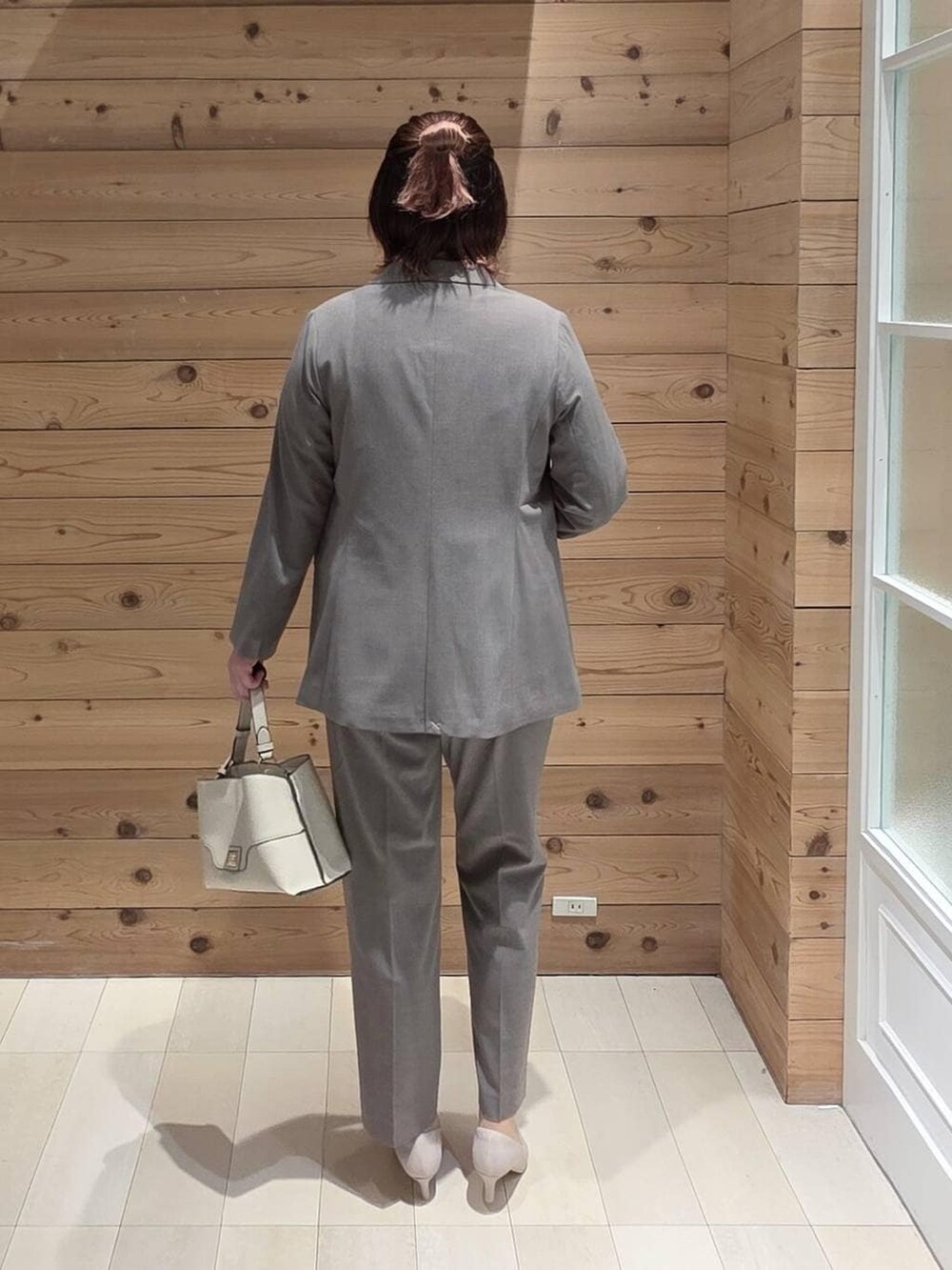 ホワイト系のパンプス、ブラウン系のスラックス、ブルー系のシャツ/ブラウスを着用したレディースの冬コーディネートの3枚目の写真