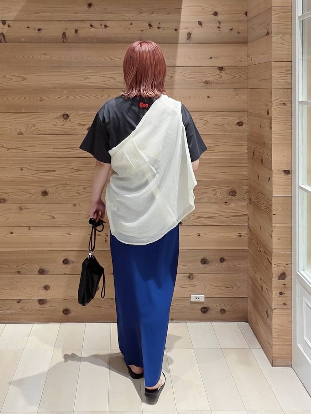 ホワイト系のシャツ/ブラウス、ブラック系のボディバッグ/ウエストポーチ、ブルー系のスカートを着用したレディースの夏コーディネートの3枚目の写真