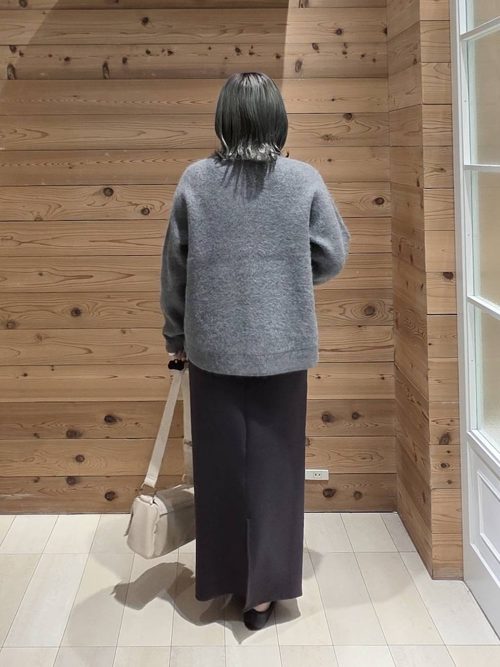 ブラック系のバレエシューズ、グレー系のカーディガン/ボレロ、ブラック系のスカートを着用したレディースの秋コーディネートの3枚目の写真