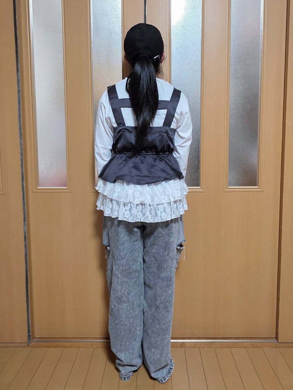 ブラック系のデニムパンツ、ホワイト系のニット/セーター、ホワイト系のスウェットを着用したキッズの秋コーディネートの3枚目の写真