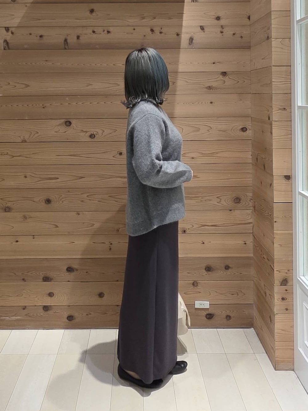 ブラック系のバレエシューズ、グレー系のカーディガン/ボレロ、ブラック系のスカートを着用したレディースの秋コーディネートの2枚目の写真