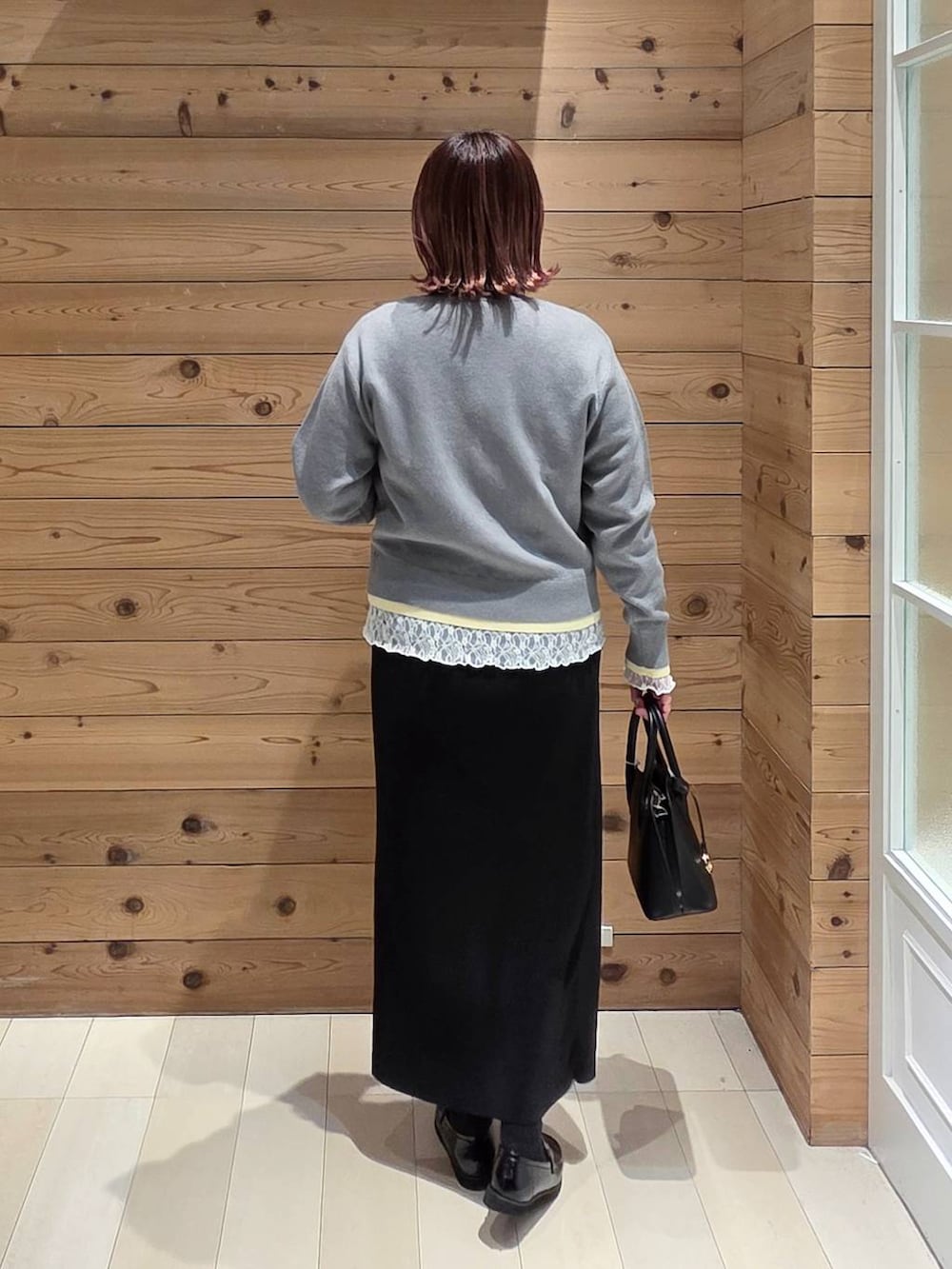 ブラック系のローファー、ブラック系のショルダーバッグ、ホワイト系のTシャツ/カットソーを着用したレディースの冬コーディネートの3枚目の写真