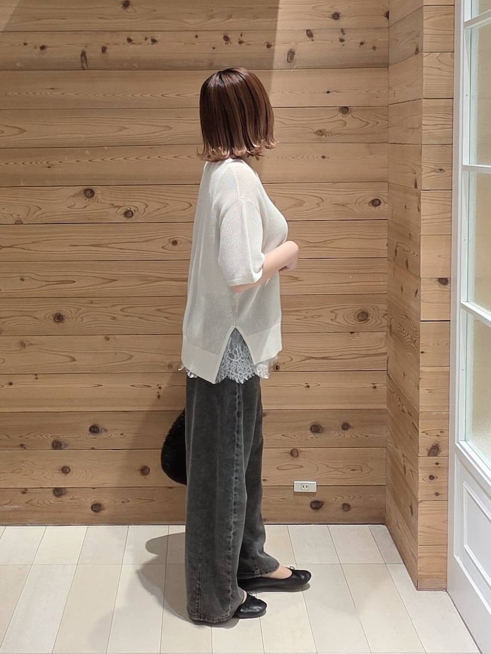 ブラック系のバレエシューズ、ブラック系のデニムパンツ、ブラック系のクラッチバッグを着用したレディースの夏コーディネートの2枚目の写真