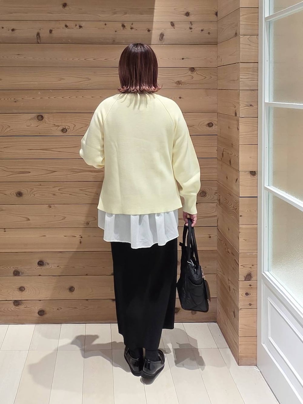 ブラック系のローファー、ブラック系のトートバッグ、ホワイト系のTシャツ/カットソーを着用したレディースの冬コーディネートの3枚目の写真