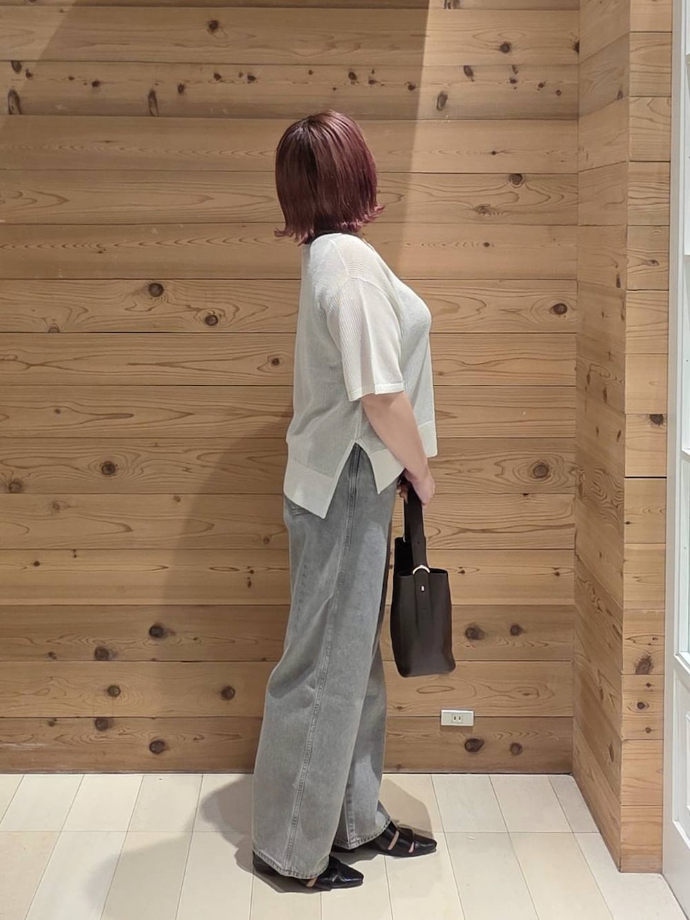 グレー系のデニムパンツ、ブラック系のショルダーバッグ、ブラック系のタンクトップを着用したレディースの夏コーディネートの2枚目の写真