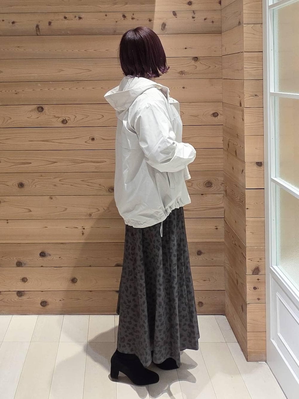 ホワイト系のマウンテンパーカー、ベージュ系のニット/セーター、ブラック系のボストンバッグを着用したレディースの冬コーディネートの2枚目の写真