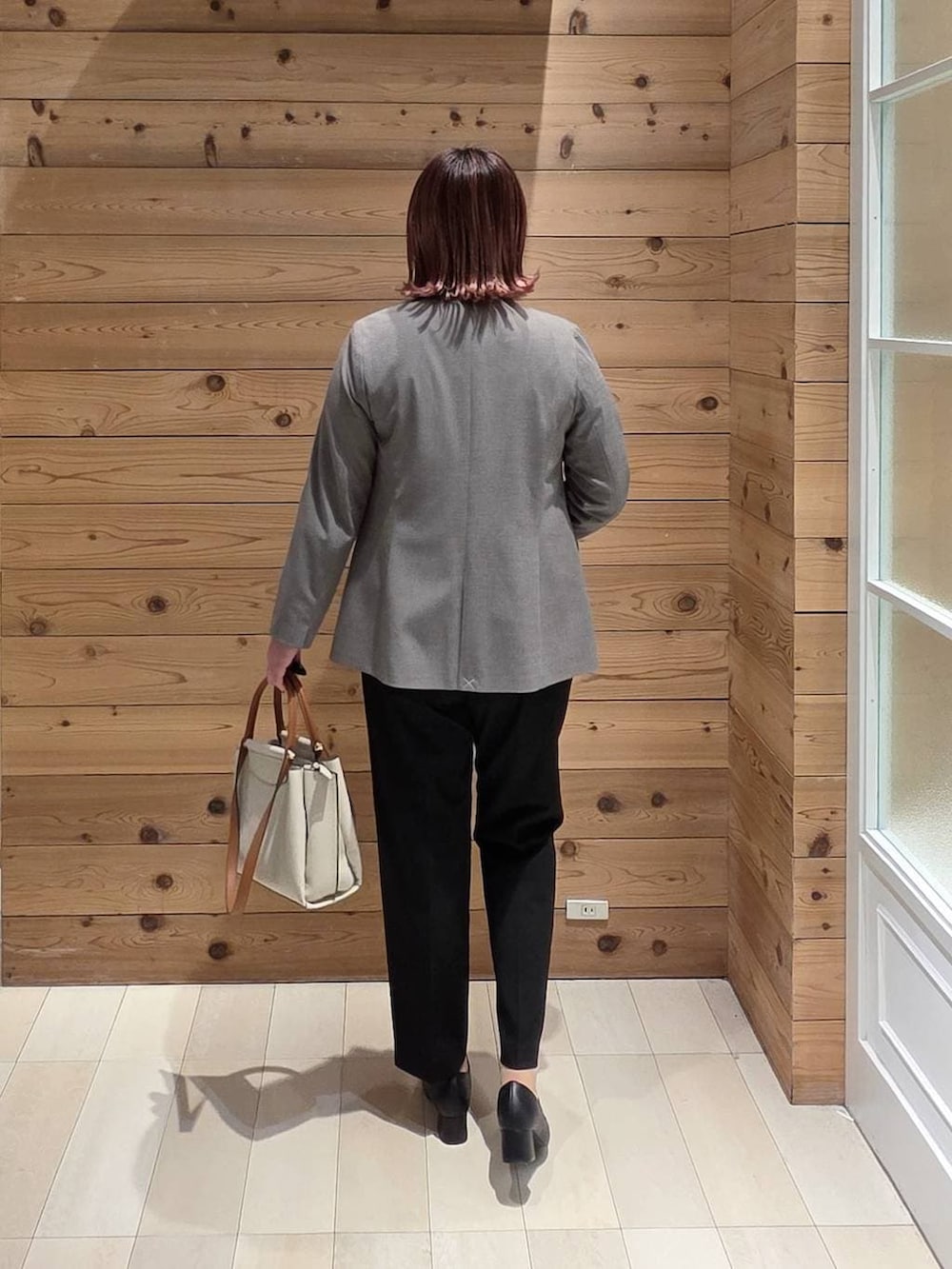 ブラック系のローファー、ブラック系のスラックス、ホワイト系のシャツ/ブラウスを着用したレディースの冬コーディネートの3枚目の写真