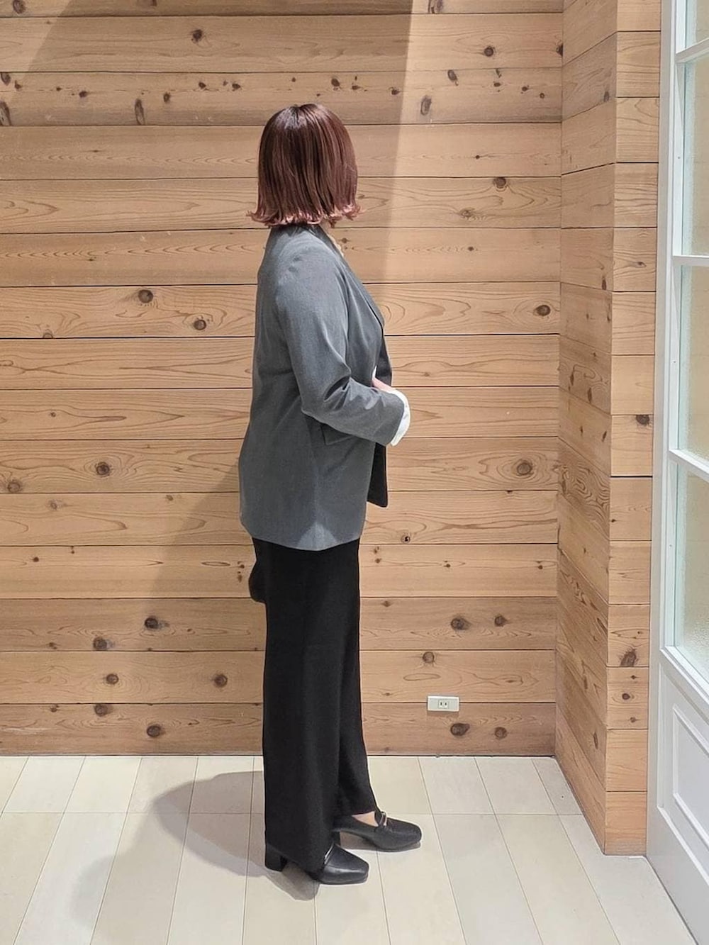 ブラック系のローファー、ブラック系のショルダーバッグ、グレー系のテーラードジャケットを着用したレディースの冬コーディネートの2枚目の写真