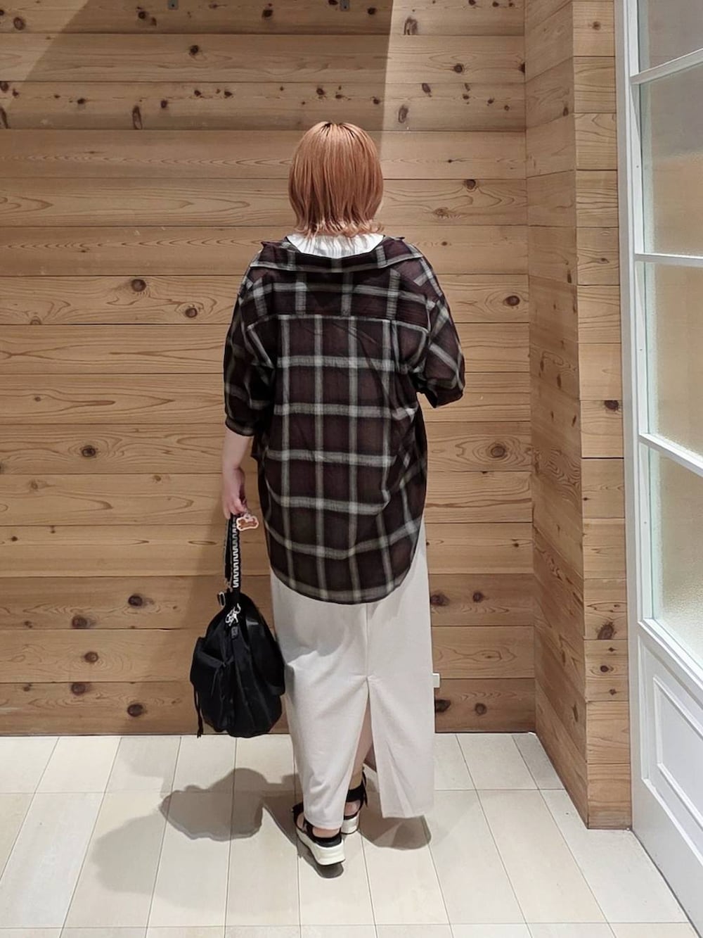 ホワイト系のスカート、ホワイト系のTシャツ/カットソー、ブラック系のサンダルを着用したレディースの夏コーディネートの3枚目の写真