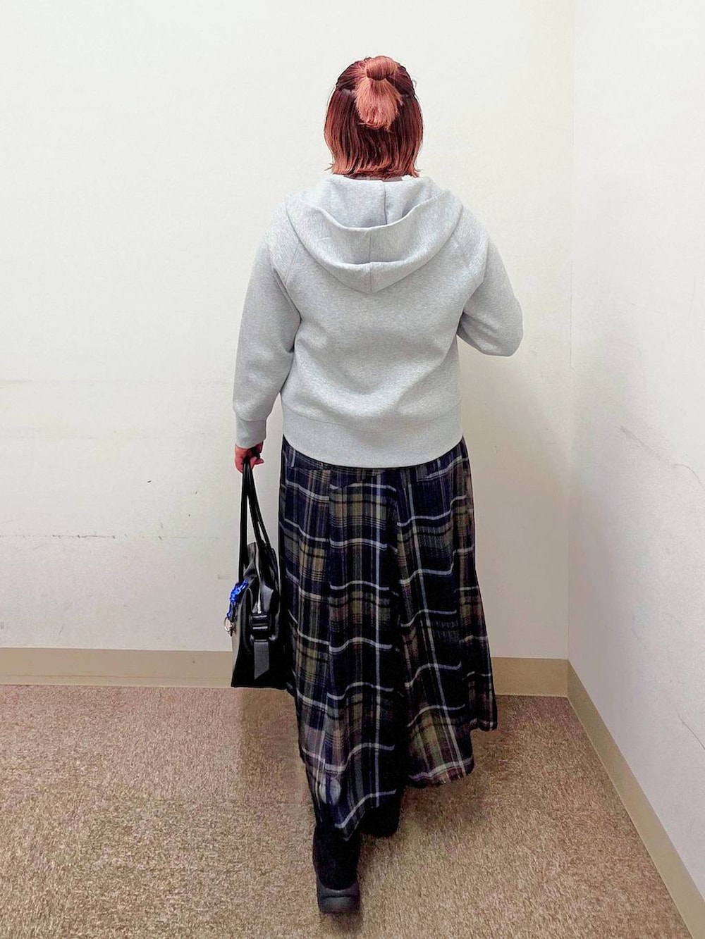 ブラック系のボストンバッグ、その他のスカート、ブラック系のブーツを着用したレディースの秋コーディネートの3枚目の写真