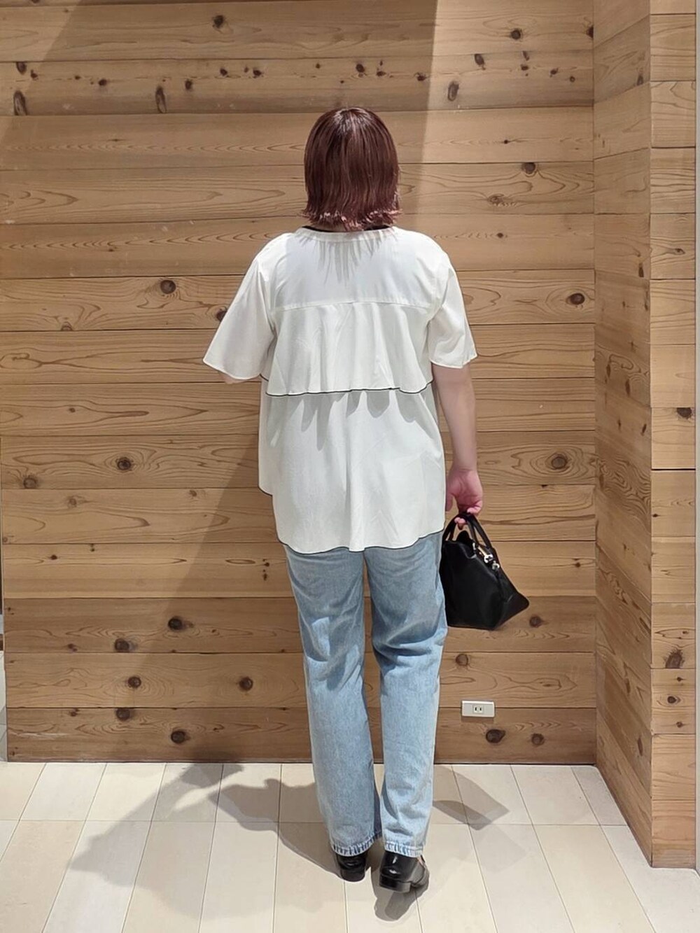 ブラック系のショルダーバッグ、ブルー系のデニムパンツ、ブラック系のタンクトップを着用したレディースの夏コーディネートの3枚目の写真