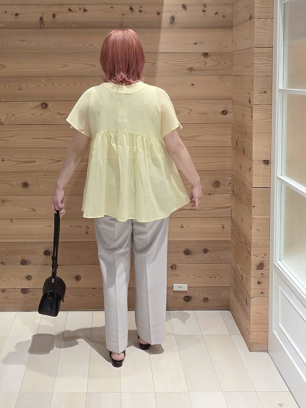 ブラック系のショルダーバッグ、グレー系のその他パンツ、イエロー系のシャツ/ブラウスを着用したレディースの夏コーディネートの3枚目の写真