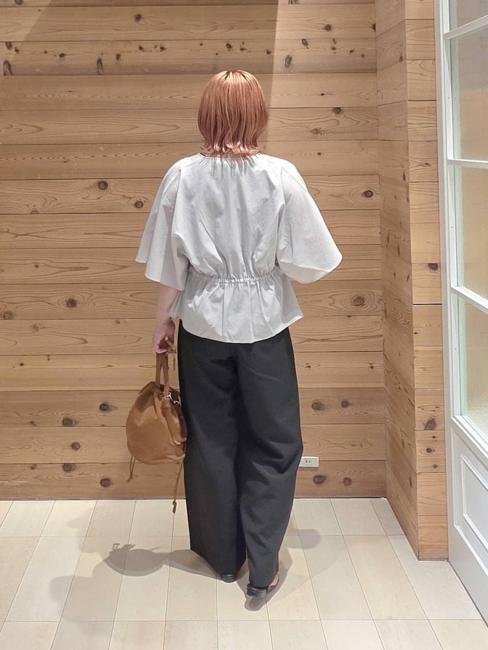 ベージュ系のハンドバッグ、ブラック系のその他パンツ、グレー系のシャツ/ブラウスを着用したレディースの夏コーディネートの3枚目の写真