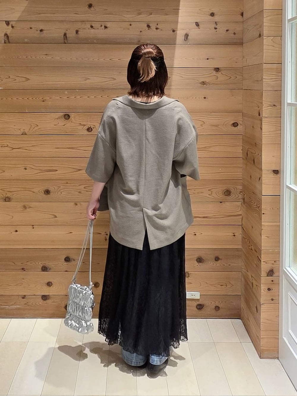 ブラック系のバレエシューズ、ブルー系のデニムパンツ、ブラウン系のテーラードジャケットを着用したレディースの夏コーディネートの3枚目の写真