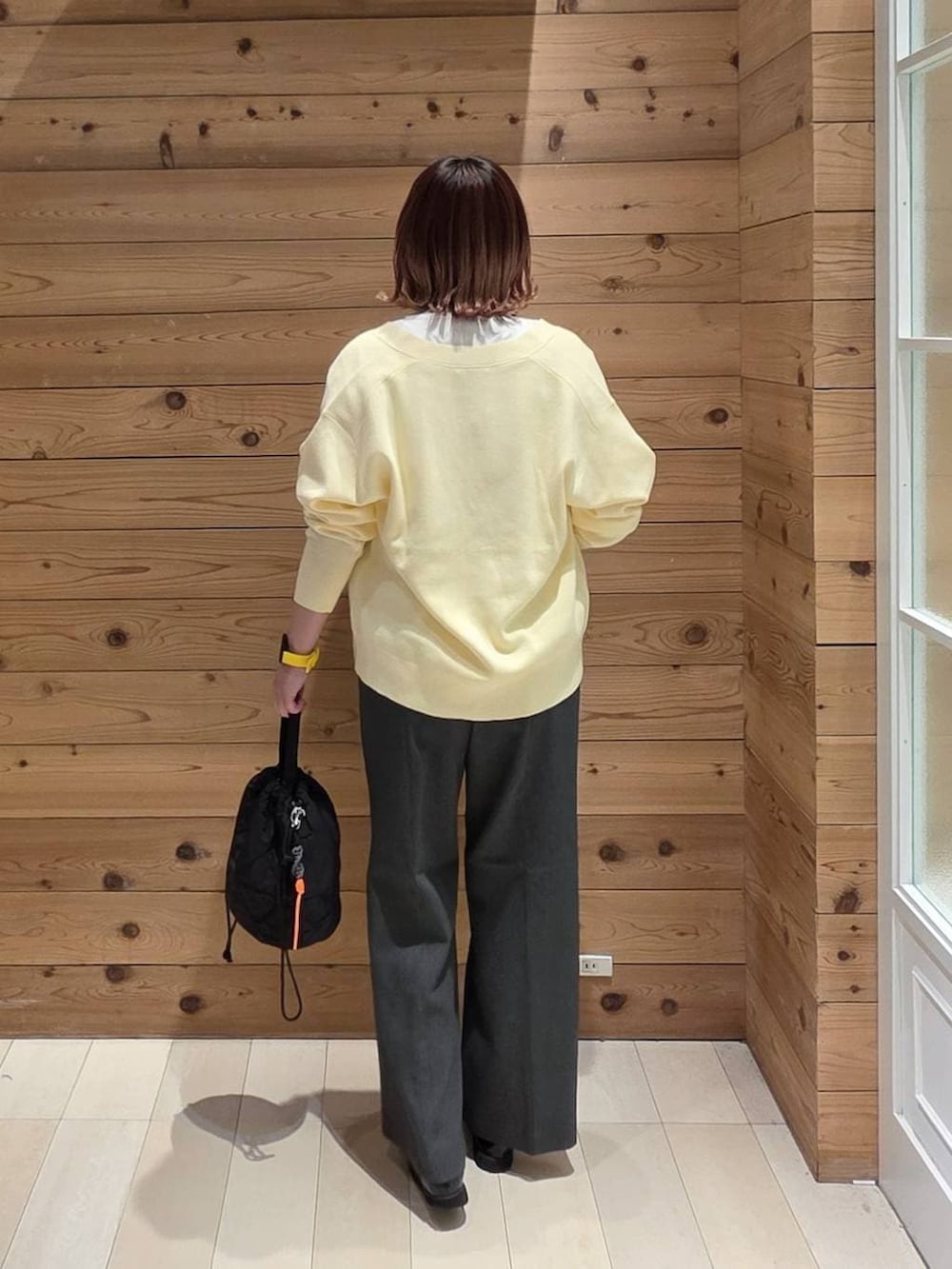 ブラック系のローファー、ブラック系のハンドバッグ、グレー系のその他パンツを着用したレディースの春コーディネートの3枚目の写真