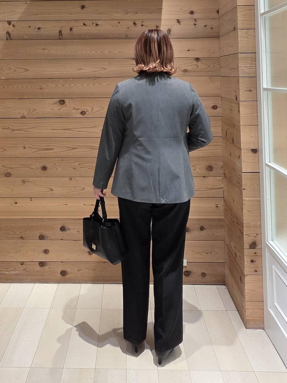 ブラック系のパンプス、ホワイト系のシャツ/ブラウス、グレー系のノーカラージャケットを着用したレディースの冬コーディネートの3枚目の写真