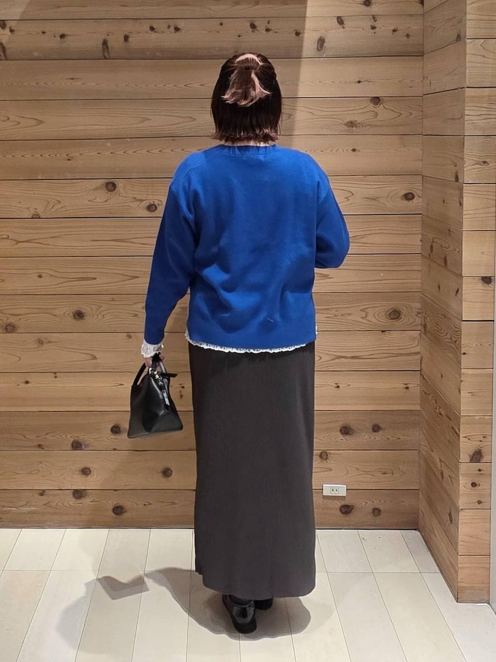 ブラック系のショルダーバッグ、ブラック系のローファー、ホワイト系のTシャツ/カットソーを着用したレディースの冬コーディネートの3枚目の写真