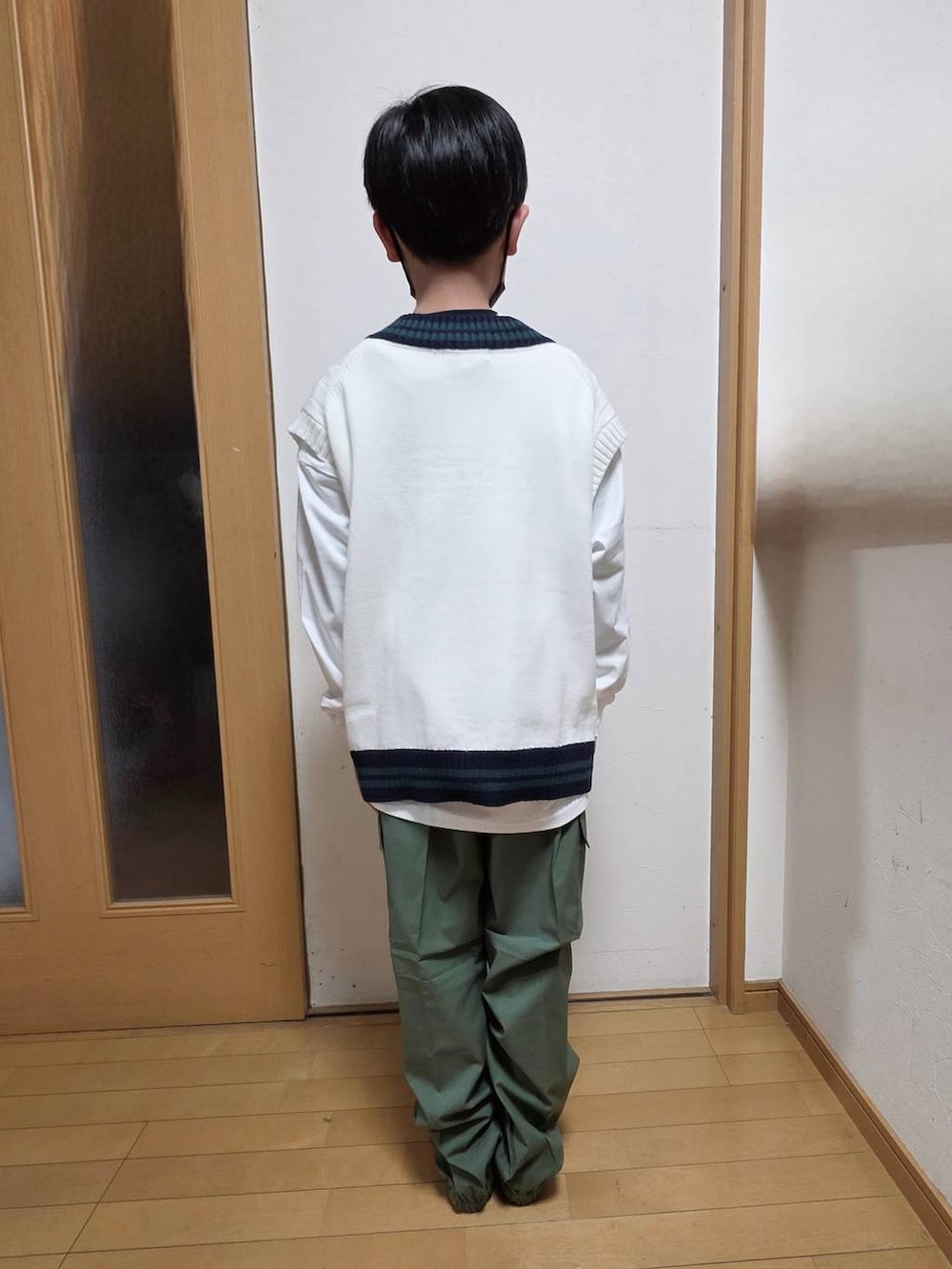 グリーン系のカーゴパンツ、ベージュ系のベスト、ホワイト系のTシャツ/カットソーを着用したキッズの春コーディネートの3枚目の写真