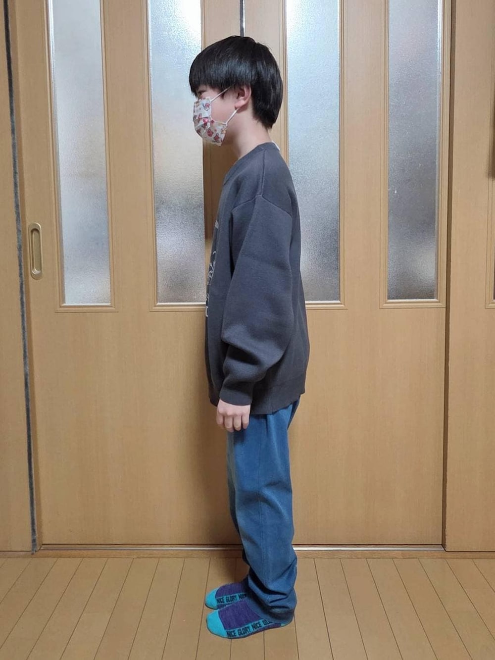 ブルー系のデニムパンツ、グレー系のニット/セーターを着用したキッズの冬コーディネートの2枚目の写真