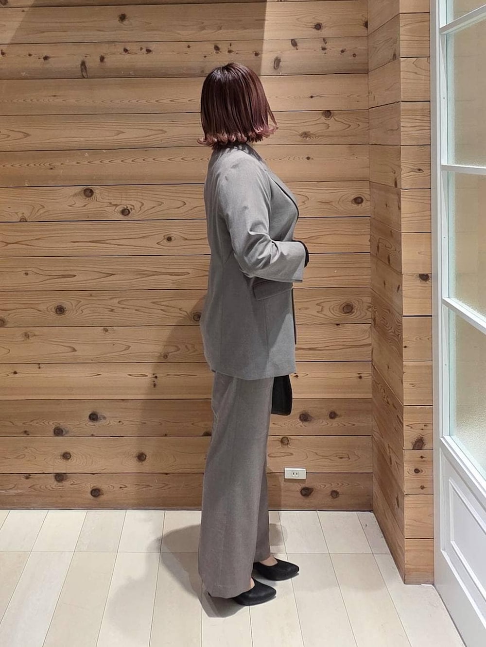 ブラック系のショルダーバッグ、ブラック系のパンプス、ブラック系のTシャツ/カットソーを着用したレディースの冬コーディネートの2枚目の写真