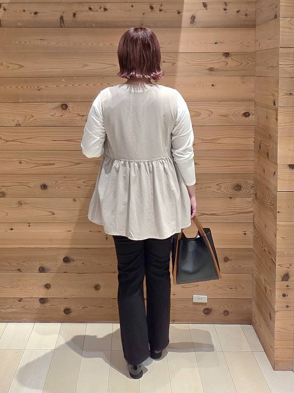 ブラック系のローファー、ブラック系のデニムパンツ、ベージュ系のベストを着用したレディースの秋コーディネートの3枚目の写真