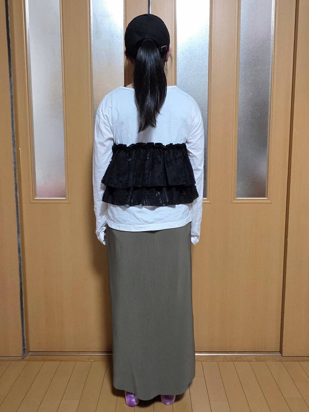 ホワイト系のTシャツ/カットソー、グリーン系のスカート、ブラック系のキャップを着用したキッズの秋コーディネートの3枚目の写真