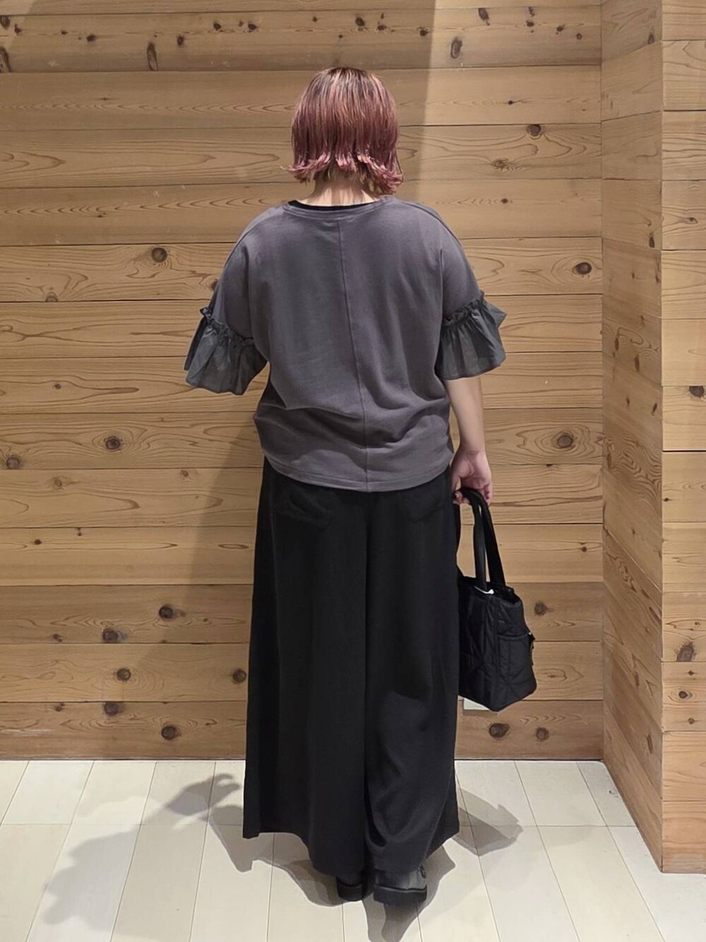 ブラック系のローファー、ブラック系のトートバッグ、ブラック系のTシャツ/カットソーを着用したレディースの夏コーディネートの3枚目の写真