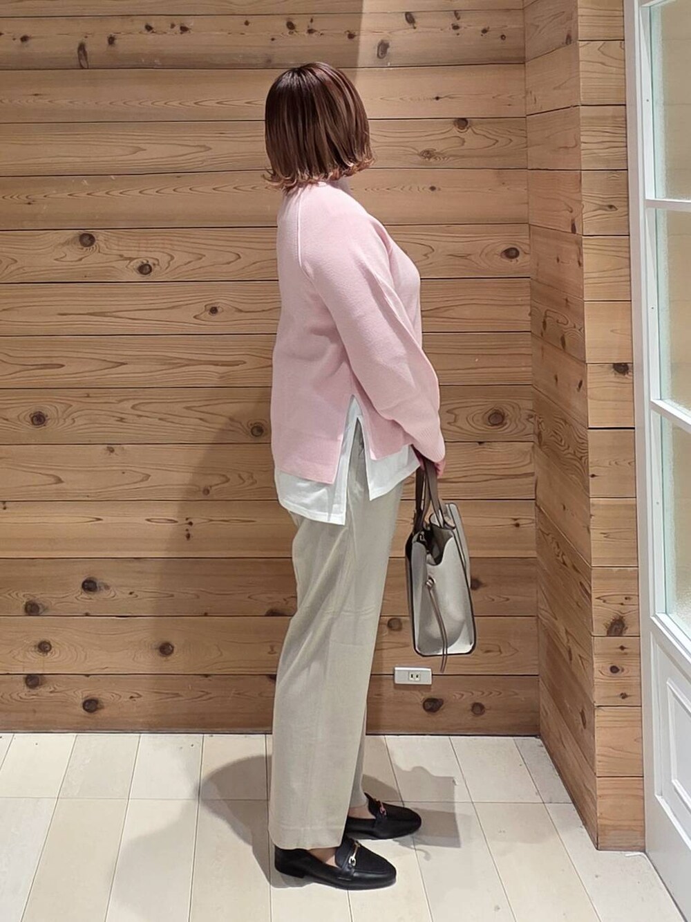 ブラック系のローファー、ホワイト系のショルダーバッグ、ブルー系のダウンジャケット/コートを着用したレディースの冬コーディネートの2枚目の写真