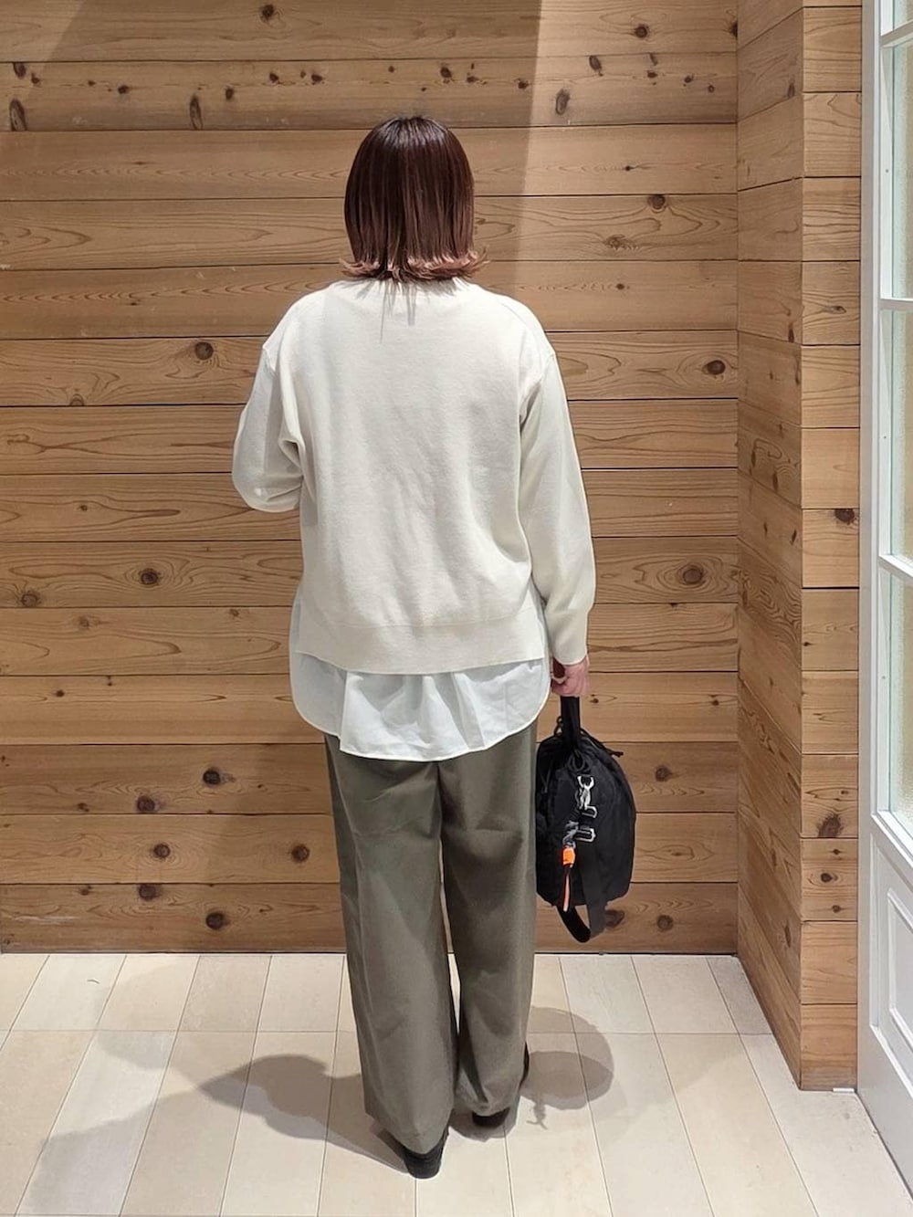 ブラック系のローファー、ブラック系のハンドバッグ、ブルー系のデニムジャケットを着用したレディースの春コーディネートの3枚目の写真